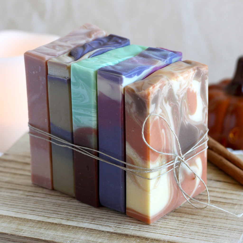 Stack of multicolored soap bars tied with string on a wooden surface