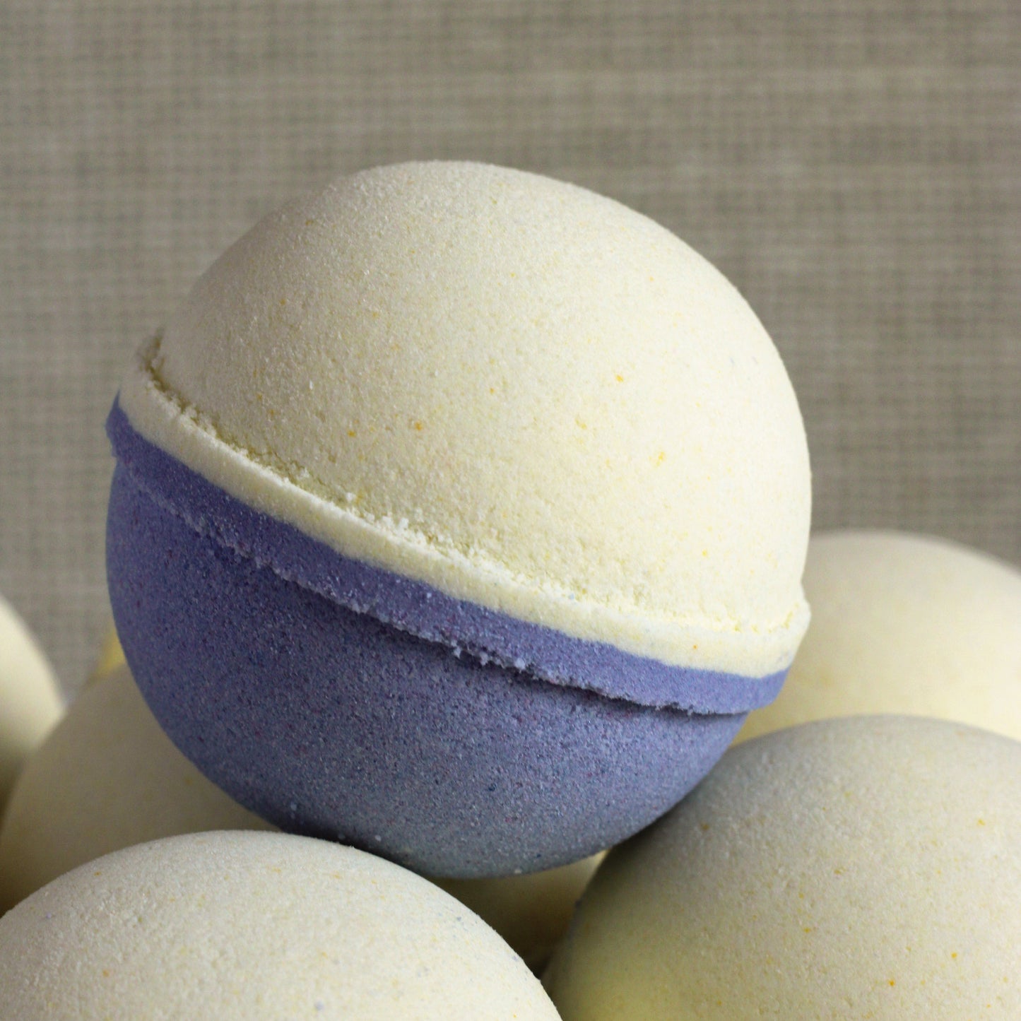 Yellow and blue-leaning purple Berry Lemonade bath bomb handcrafted by Missouri River Soap