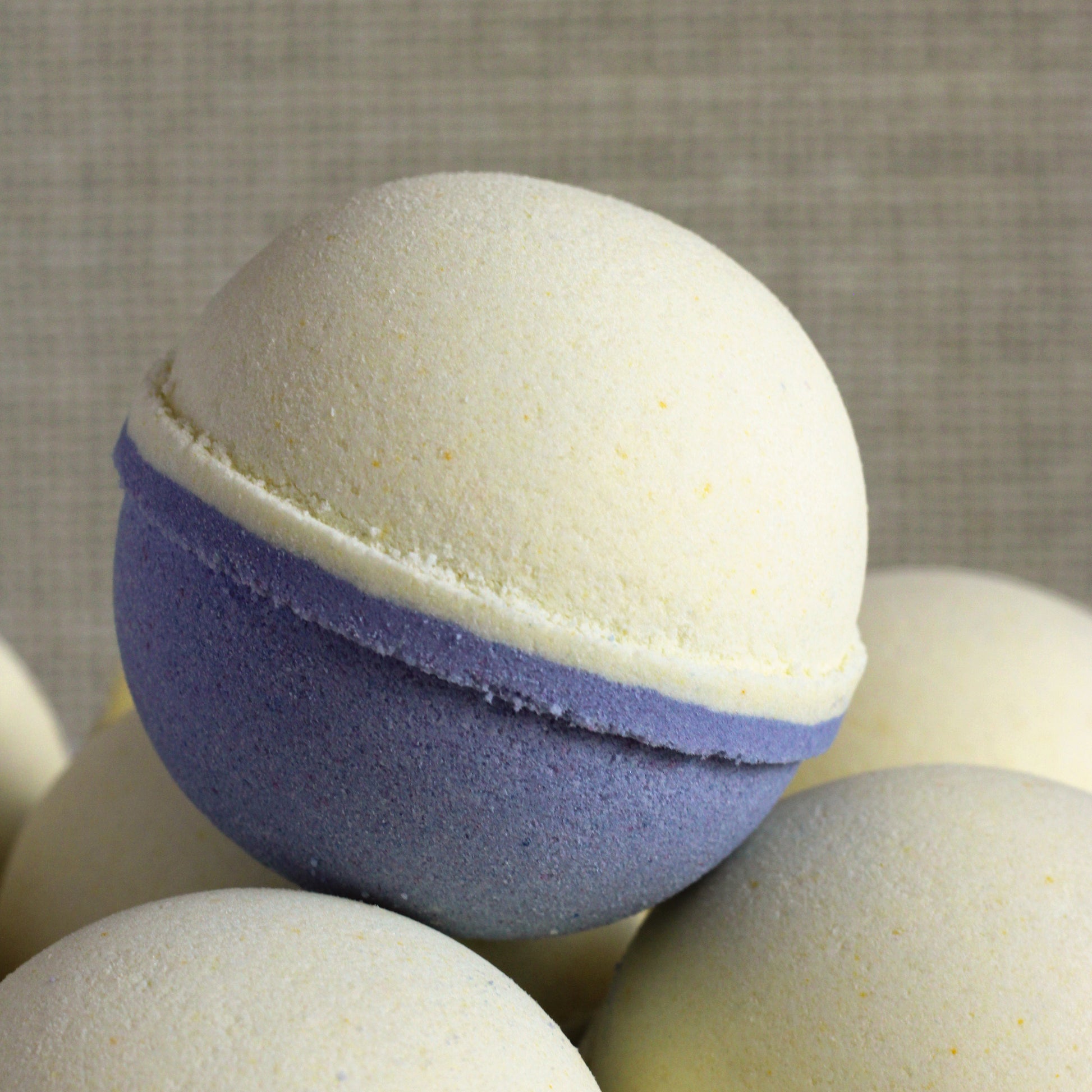 Yellow and blue-leaning purple Berry Lemonade bath bomb handcrafted by Missouri River Soap