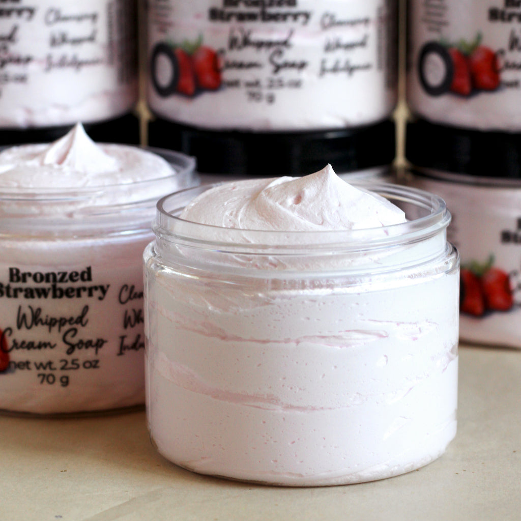 Jar of Bronzed Strawberry Whipped Cream Soap with product packaging in the background.
