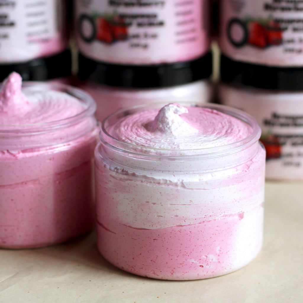 Pink and white sugar scrub in jars with visible brand labels in the background.