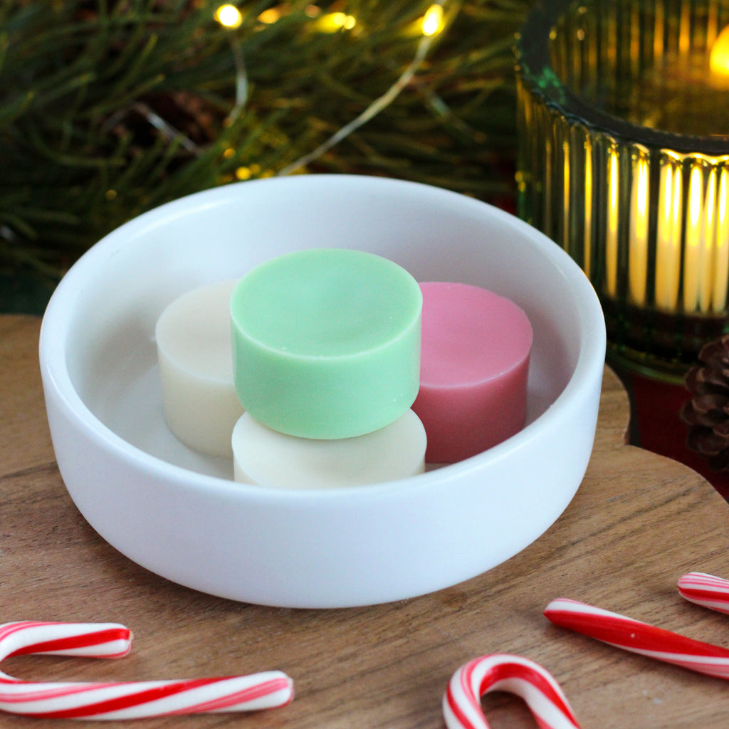 Missouri River Soap Buttermint wax melts – little disk-shaped melts in white, pink, and mint green, releasing a creamy blend of cool peppermint and warm vanilla, filling your space with a playful, festive fragrance.