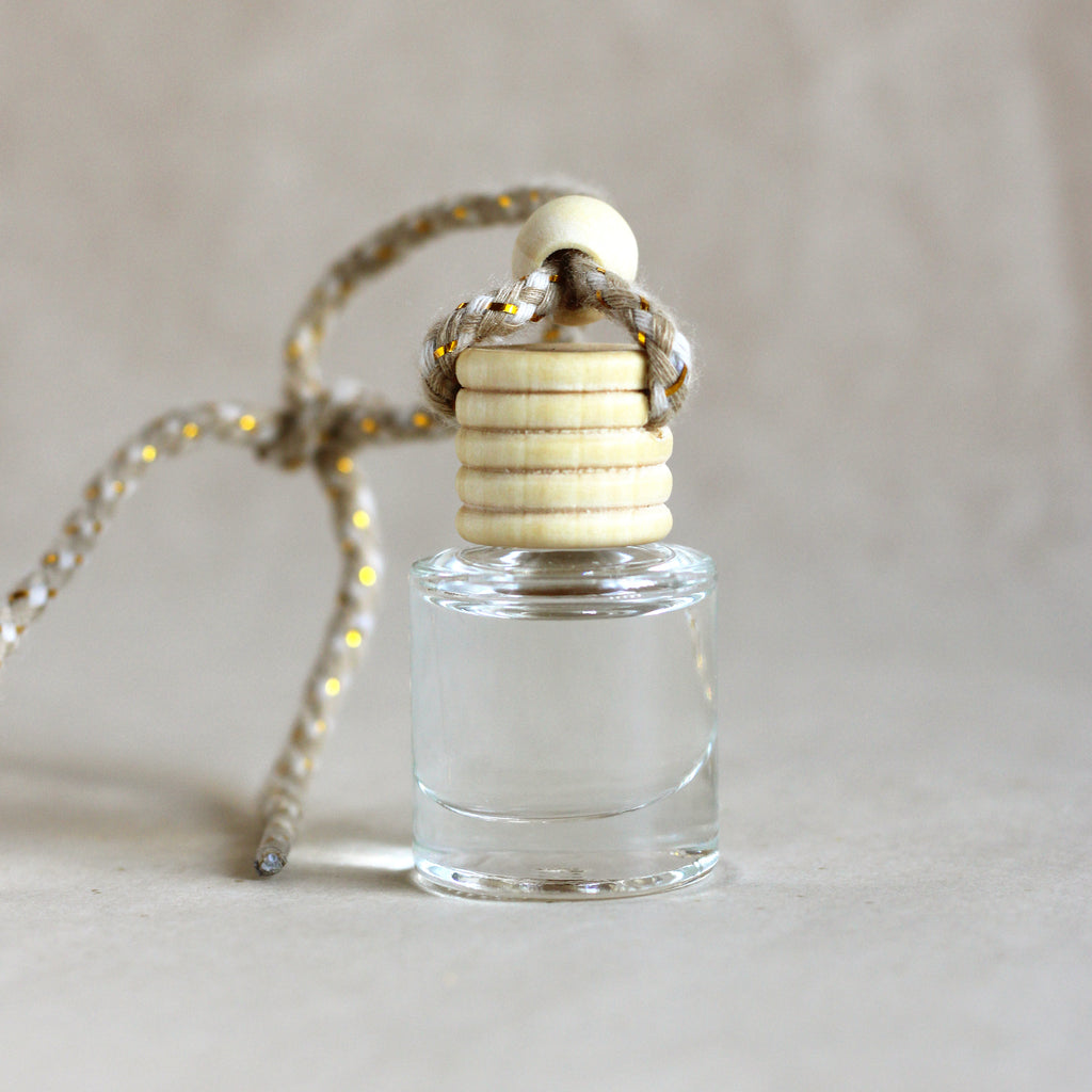 Small glass bottle with wooden cap on a neutral background