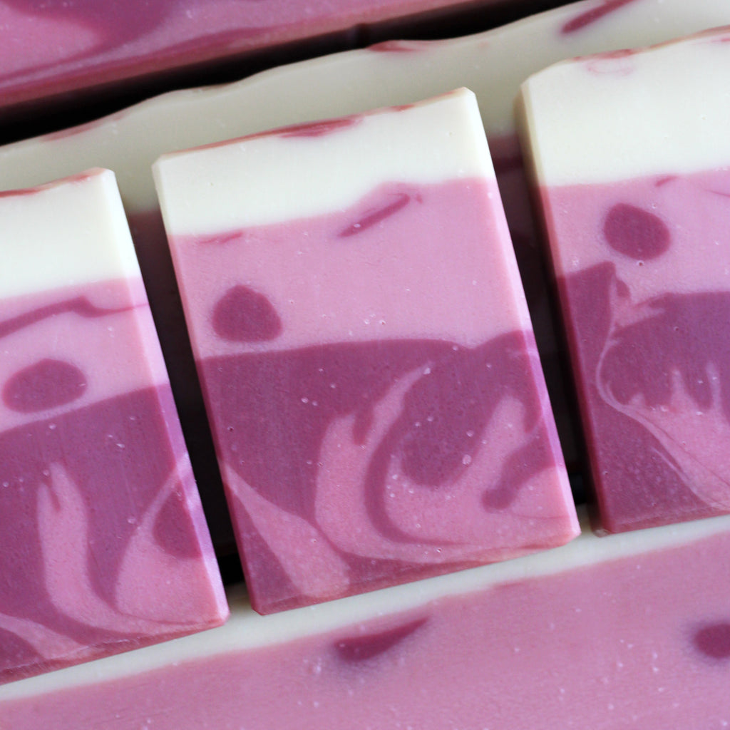 Pink and cream swirled soap bars arranged in a row.