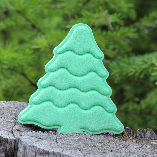 Evergreen tree-shaped bath bomb by Missouri River Soap photographed on a tree stump in the forest