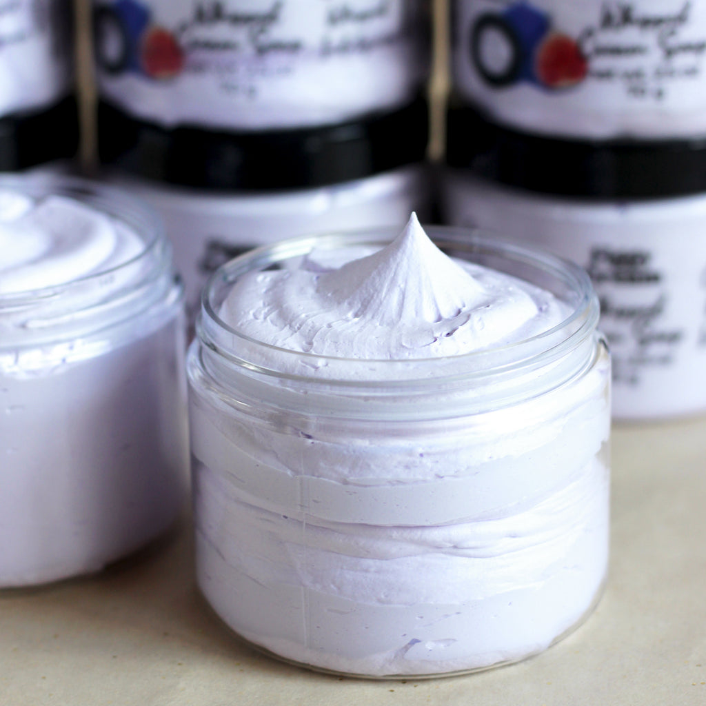 Jar of pastel purple cream soap on a beige surface