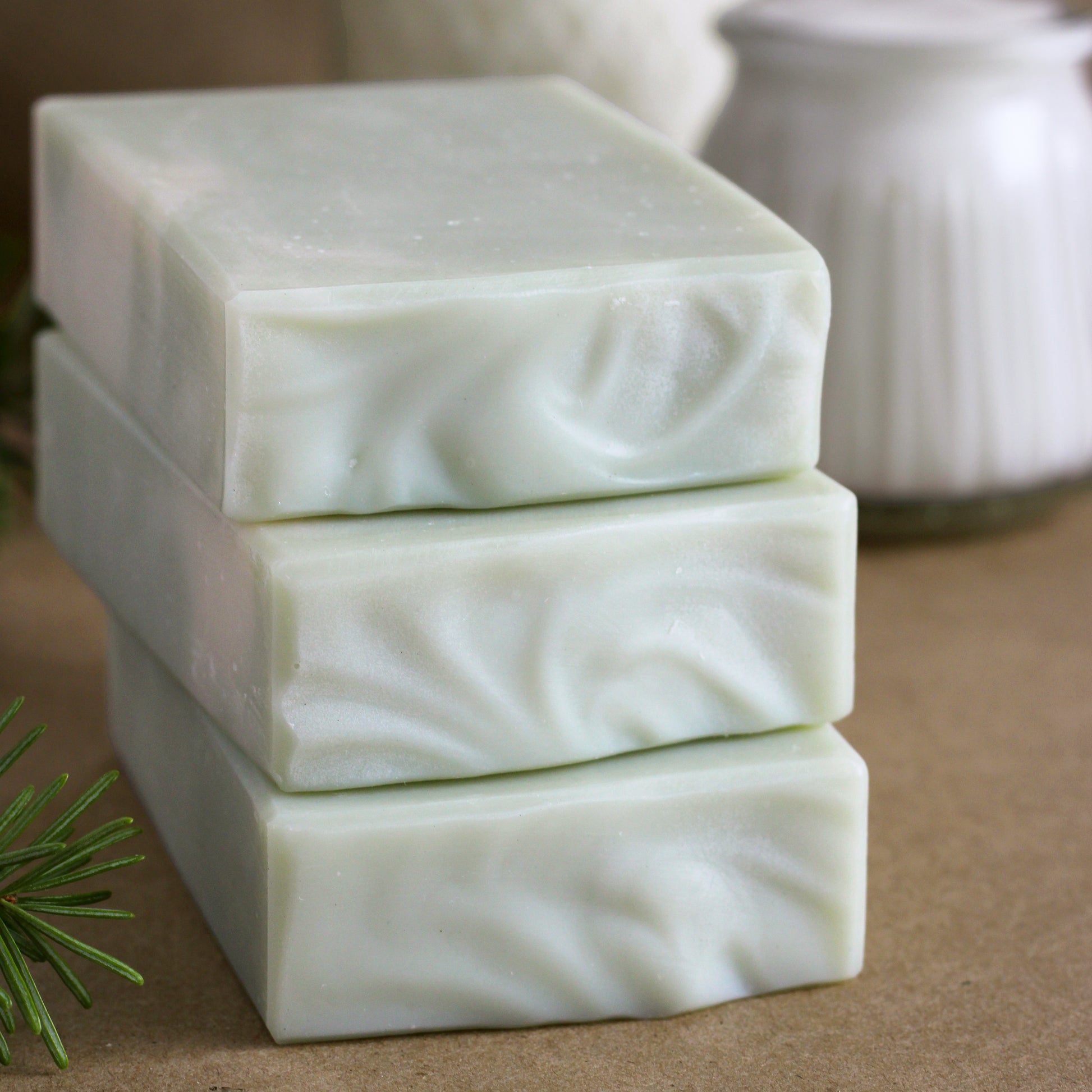 Missouri River Soap Fir Needle Tallow Soap featuring three creamy white handcrafted soap bars stacked on kraft paper with goat milk kefir, sheep's milk yogurt, and a fresh fir sprig in the background.