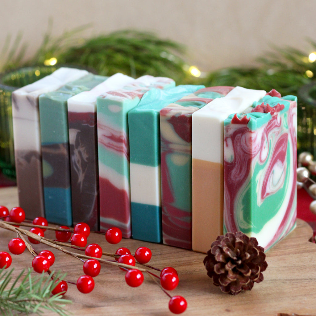 Missouri River Soap Holiday Soap Sampler – eight colorful bars of our festive holiday soaps lined up, displayed in a cheerful, seasonal setting.