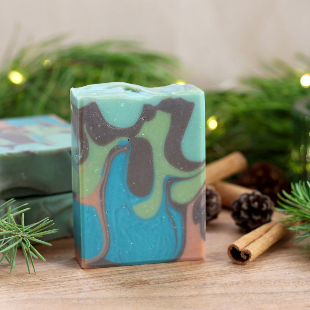 Missouri River Soap Lodge – green, brown, and orange swirled soap with warm woodsy holiday scent, notes of orange peel, ginger, clove, and pine
