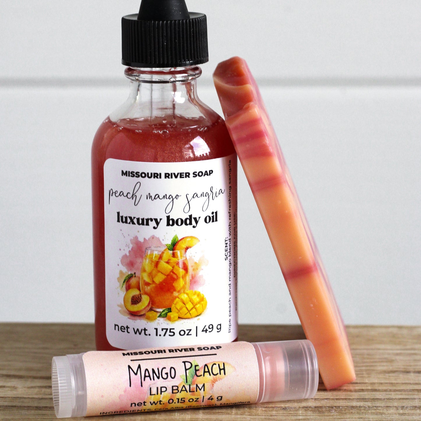 Peach Summer Glow Set featuring handcrafted peach mango sangria soap, shimmering body oil, and lip balm arranged together in a coordinated summer skincare gift set by Missouri River Soap