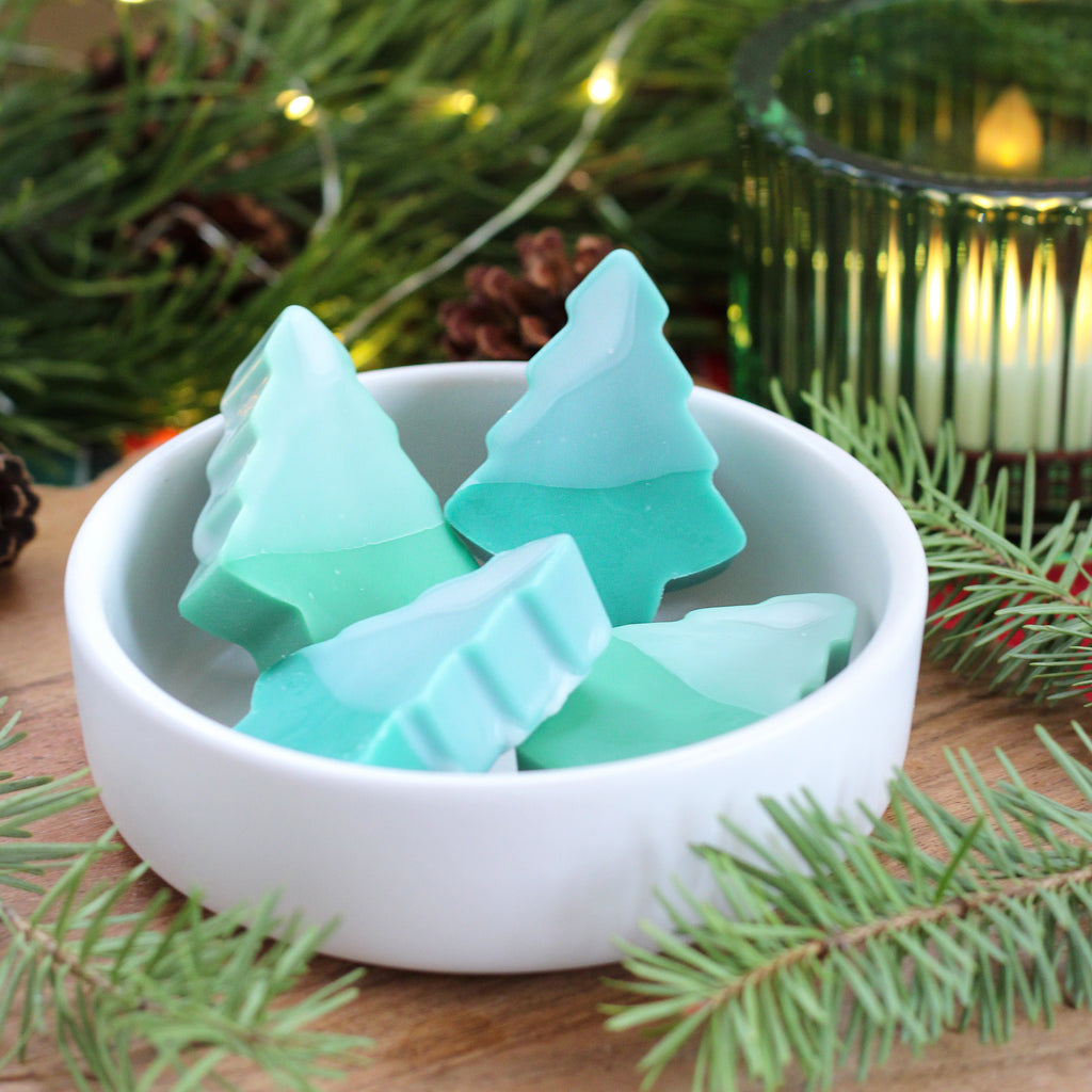 Missouri River Soap Snow Drift wax melts – pine tree-shaped melts in two shades of green, each topped with white “snow,” releasing a refreshing blend of sparkling icicles, cedar bark, and warm sandalwood.