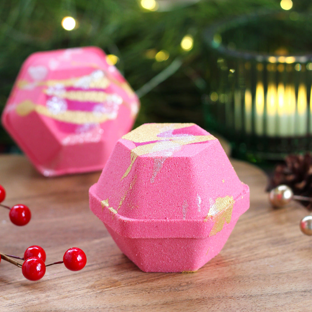 Missouri River Soap Snow Kissed Bath Bomb – festive pinky-red bath bomb with mica drizzle and deep burgundy mini inside; scent of candied apple, orange zest, warm spice, and earthy undertones