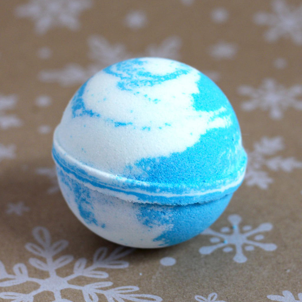 Winter Wonderland bath bomb with swirls of blue and white, on a snowflake-printed kraft background